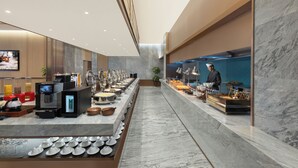Ein modernes Buffet mit vielfältigen Speisen und einer Kaffeestation.