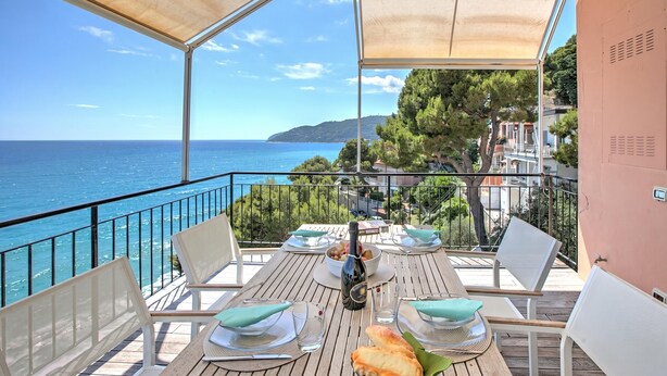 Mesa para dos con una botella y copas, con vista al mar.