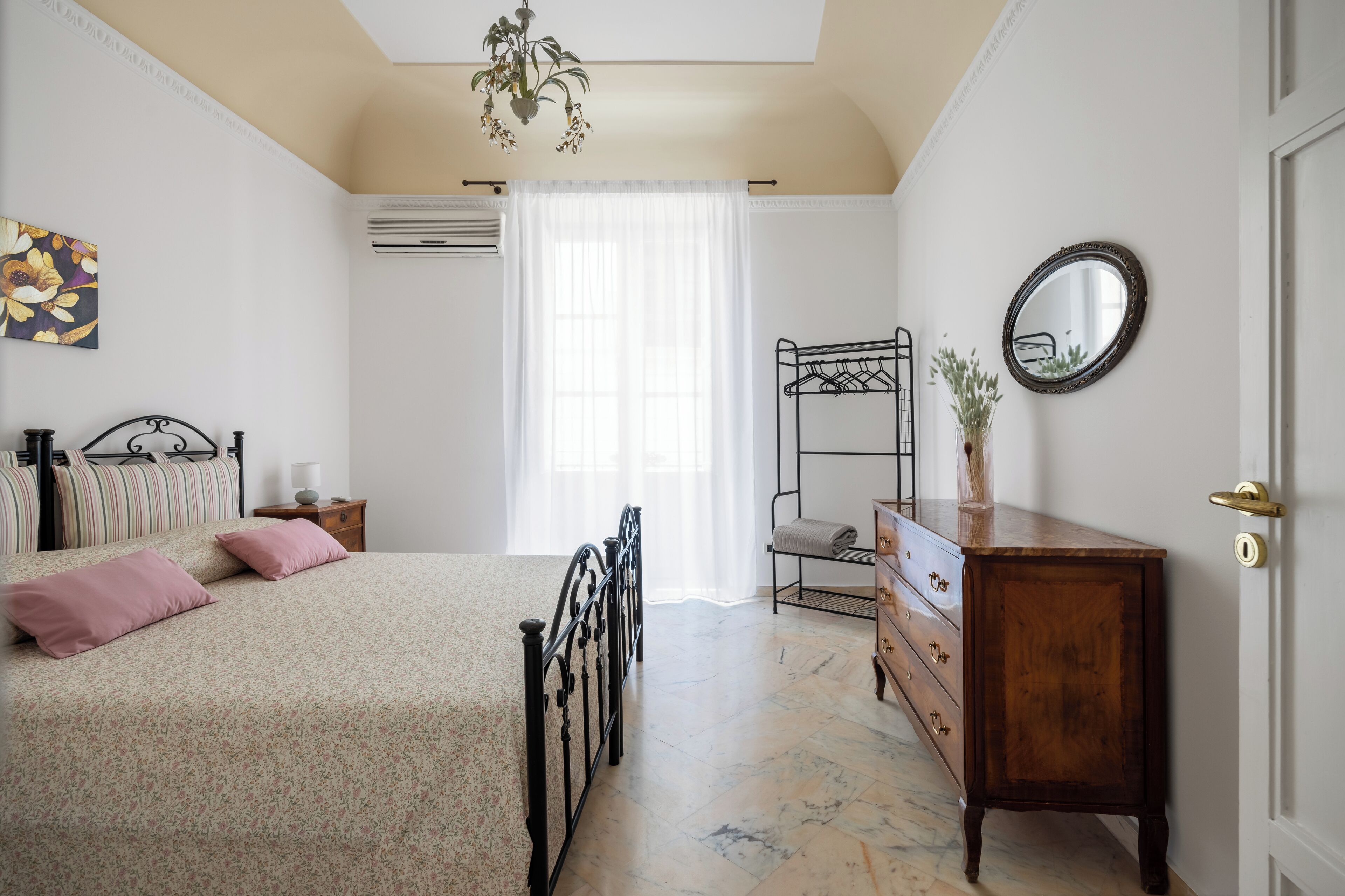 A bedroom with a bed, dresser, and a mirror.