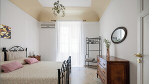 Une chambre à coucher avec un lit, une commode et un miroir.