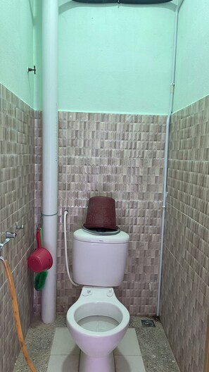 Ein kleines Badezimmer mit Toilette, Dusche und einem Fön.