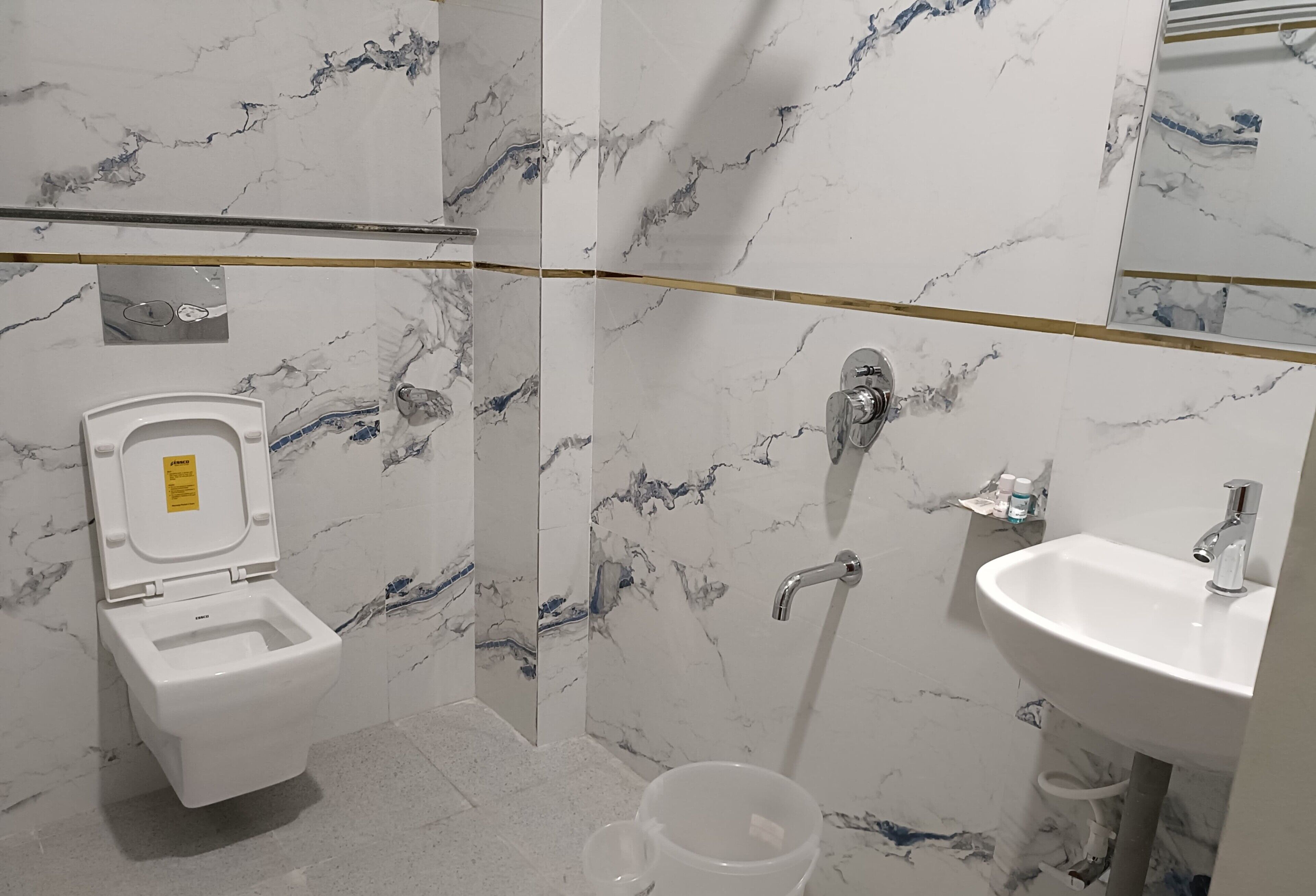 Une salle de bain avec des toilettes, un lavabo et une douche.