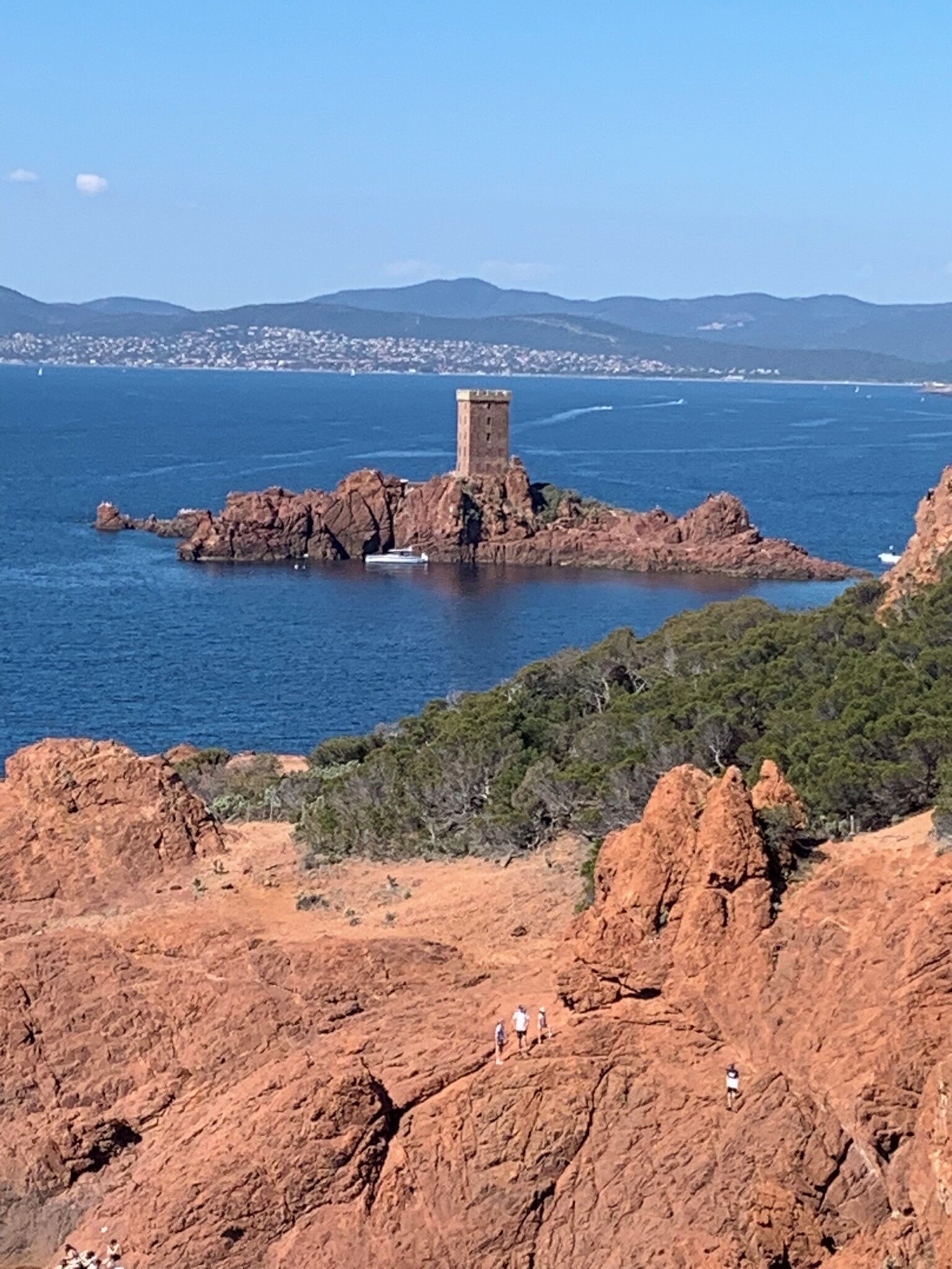 Un paysage côtier caractérisé par une formation rocheuse imposante, sur laquelle se dresse une structure ressemblant à une tour.