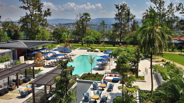 Un resort con piscina, sillas de descanso y sombrillas.