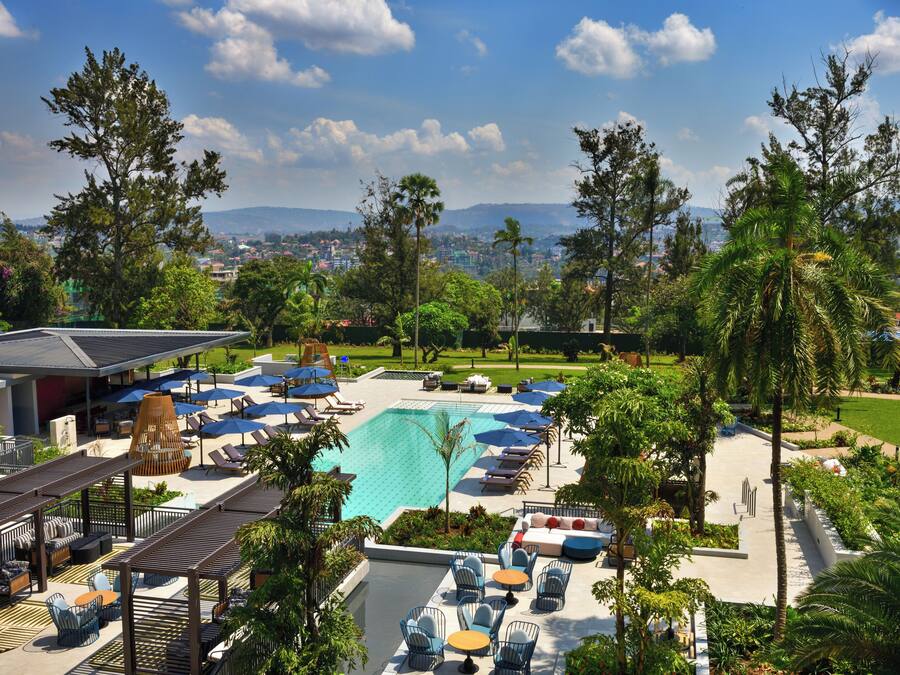 Un resort con piscina, sillas de descanso y sombrillas.