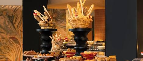A buffet with various food items displayed on stands and in baskets.