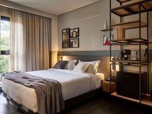 A modern hotel room with a bed, bedside tables, a built-in TV, and a shelf with amenities. - Tribe Belo Horizonte Savassi (Belo Horizonte)