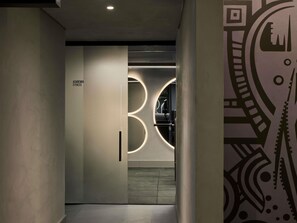 A hallway with a sign reading 'ACADEMIA FITNESS' and a circular light fixture. - Tribe Belo Horizonte Savassi (Belo Horizonte)