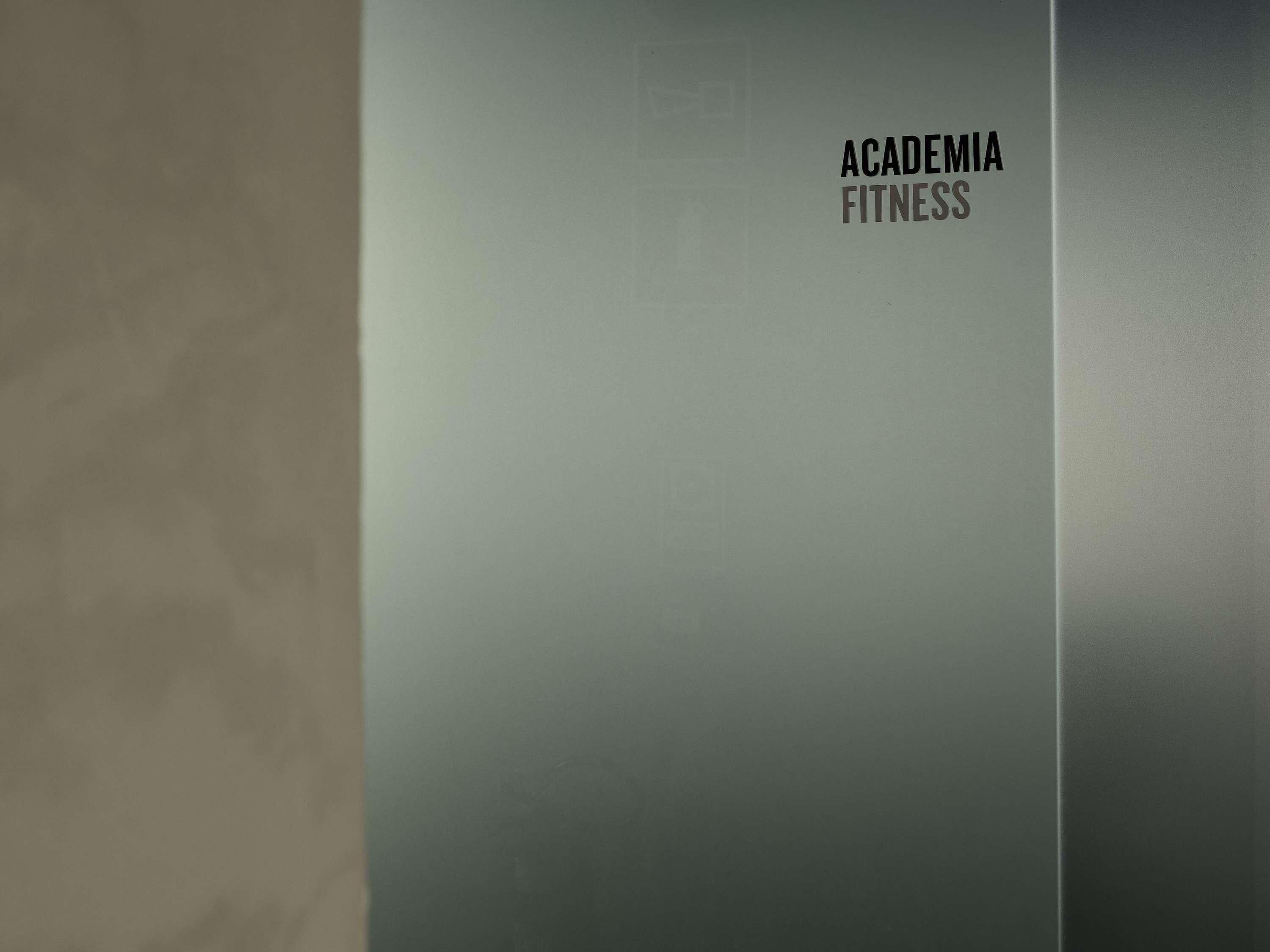 Una pared con el texto 'ACADEMIA FITNESS'.