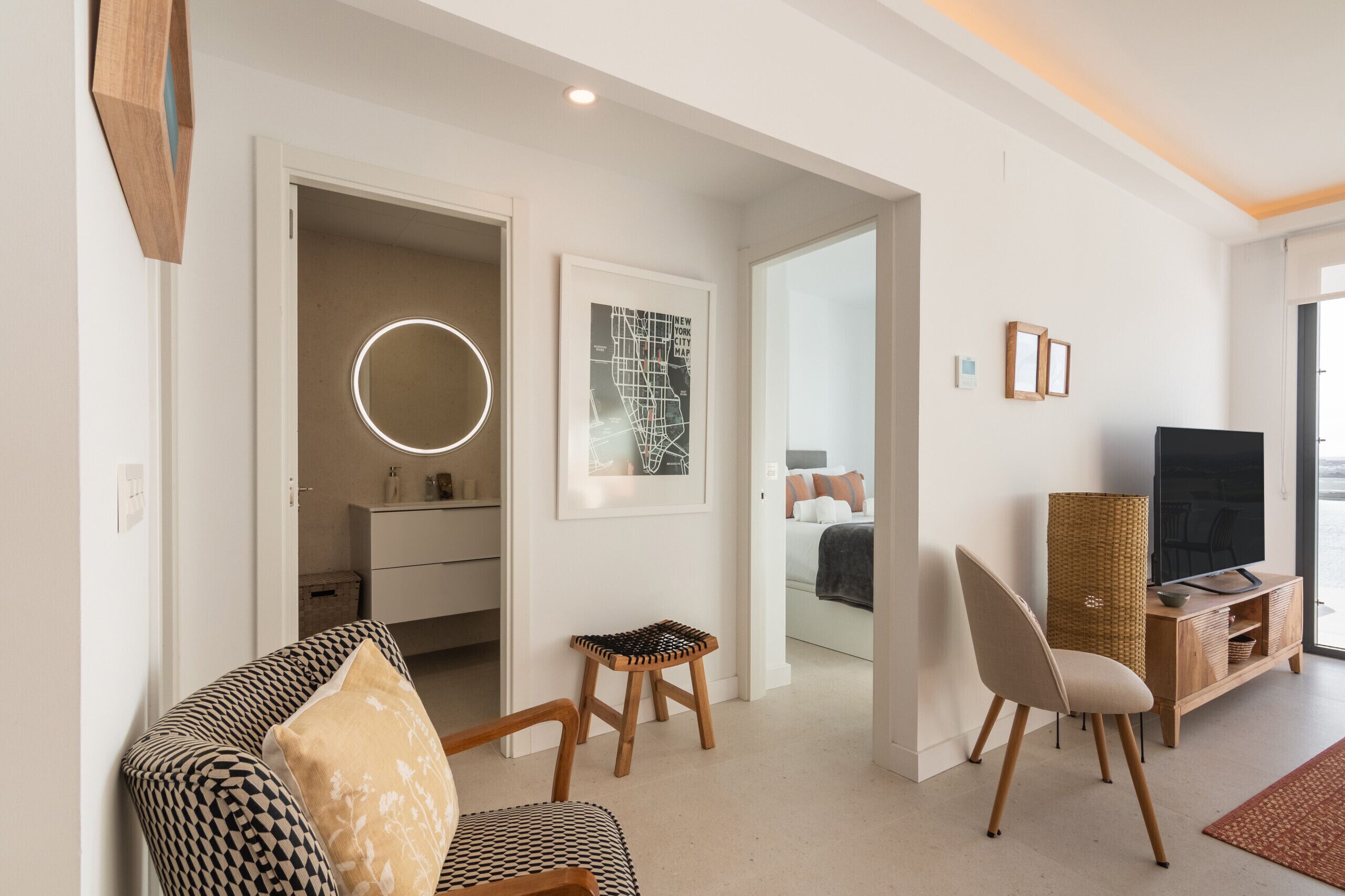 Una sala moderna con sofá, sillas, televisor y comedor.