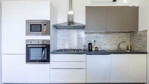 A modern kitchen with a built-in microwave, oven, and gas stove. - Le Olive House by Wonderful Italy (Sanremo)