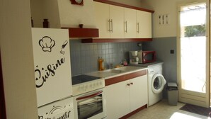 A kitchen with a refrigerator, oven, microwave, and washing machine. - Herault coquet F2 Maraussan 34370 (Maraussan)