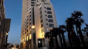A high-rise hotel with multiple floors, illuminated windows, and a prominent sign at the top.