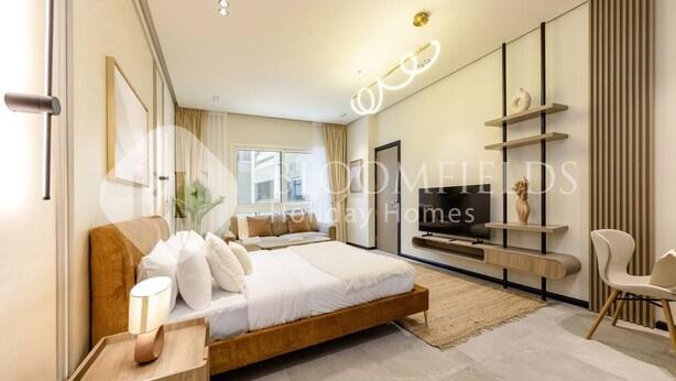 Een moderne slaapkamer met een groot bed, een televisie en een minimalistische inrichting.