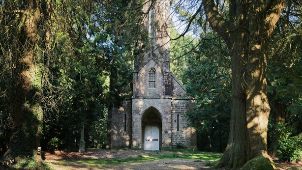 A stone church with an arched entrance, surrounded by trees. - Rental for 2 people, 7 km from Louvigné-du-Désert (35420) (Monthault)
