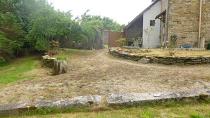 A rustic stone building with a stone pathway leading to a wooden door.