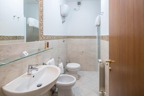 A bathroom with a sink, toilet, and shower.