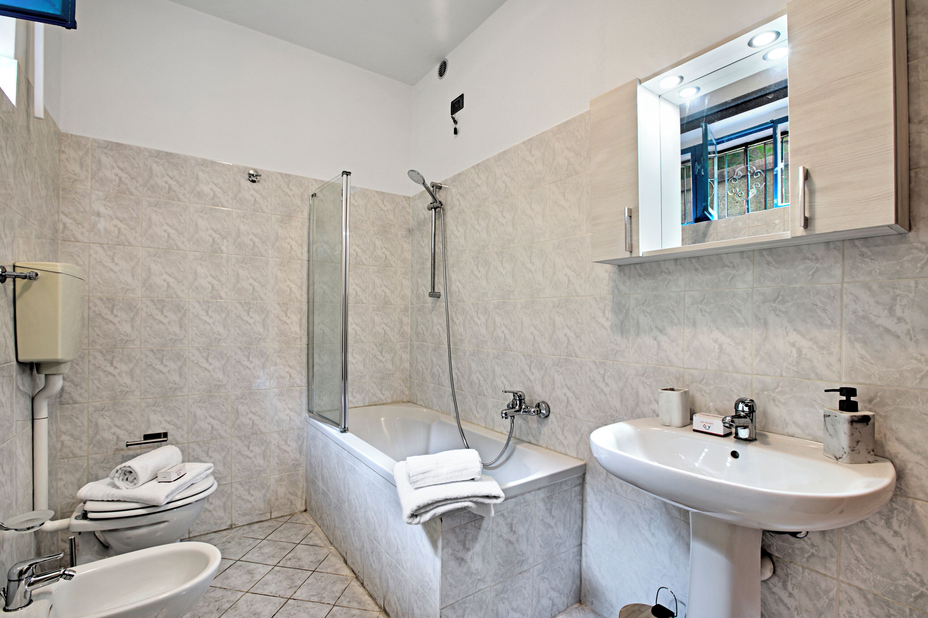 A modern bathroom with a bathtub, a sink, and a toilet.