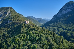 A mountain landscape with a small building on a hill.