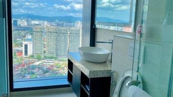 A modern bathroom with a large window, a toilet, and a sink.