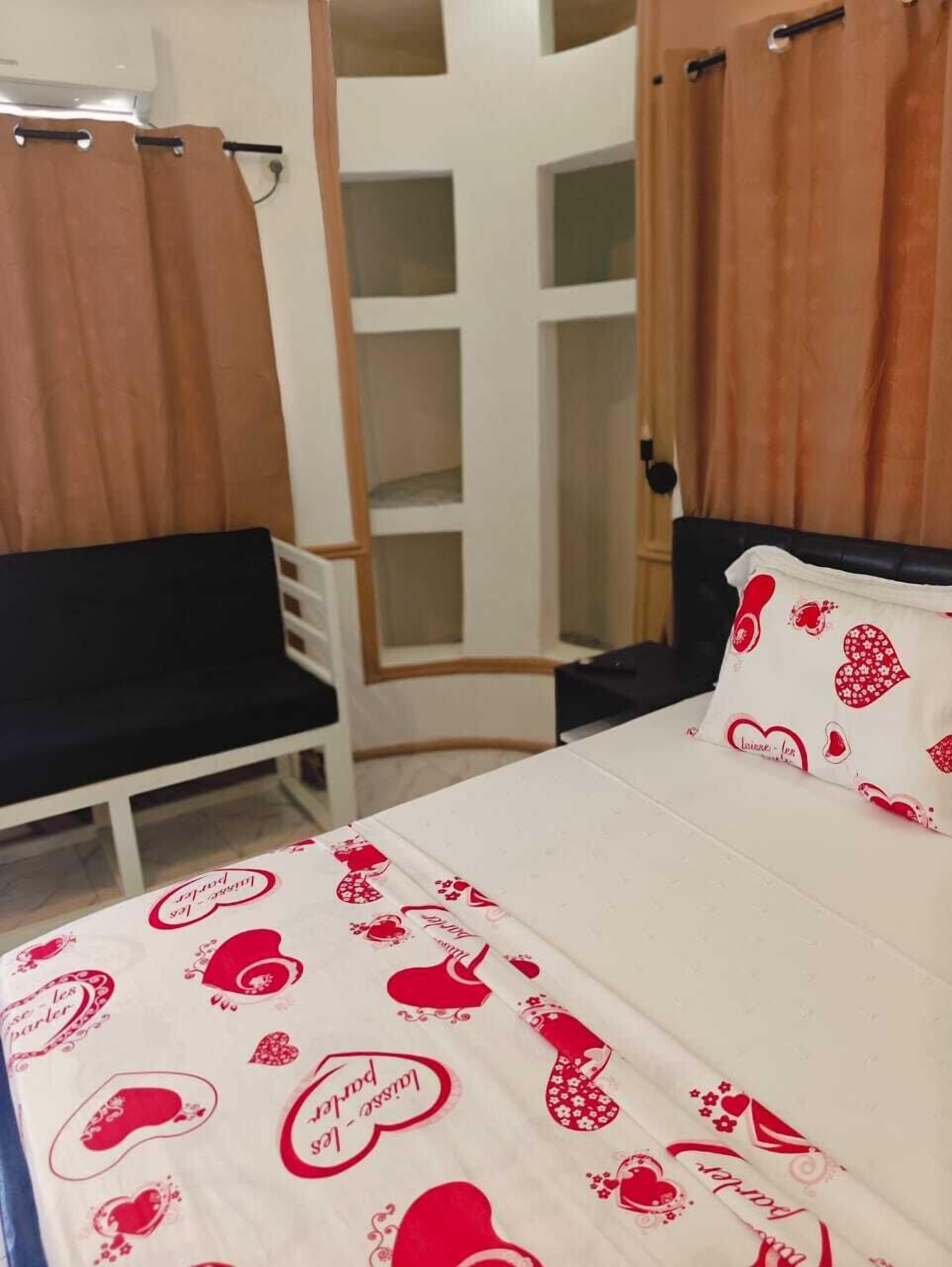 A bedroom with a bed, a chair, and a wardrobe.