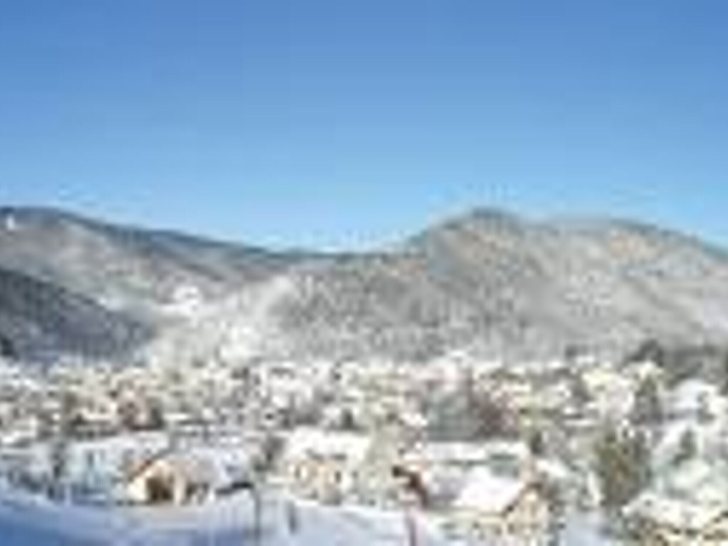 Un paysage de montagne enneigé, avec une ville au premier plan.