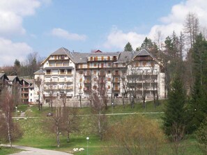 A multi-story building with a symmetrical facade, multiple balconies, and a central entrance.