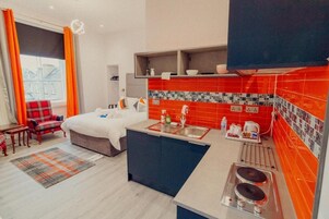 Luxe studio suite, uitzicht op tuin | Een bureau, een laptopwerkplek, een strijkplank/strijkijzer