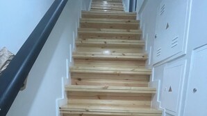 A wooden staircase with white lockers on the right side. - Portu Sereno Emerald - Floor 1 (Setúbal)