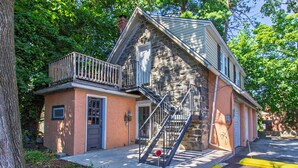 A two-story stone building with a balcony and a fire escape. - Comfy 1 BR Hide Away Apt w/ Garage Parking (Bryn Mawr)