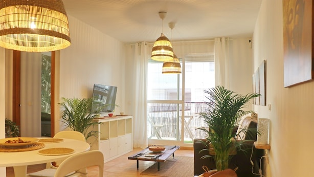 Een moderne woonkamer met een eetgedeelte, grote ramen en uitzicht op de omgeving.