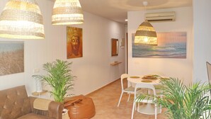 Een modern interieur met rieten hanglampen, een Boeddha-schilderij en uitzicht op de oceaan.