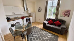 A compact living space with a kitchen, dining area, and seating area. - Cozy Croydon Apartment With Central Heating & Free Parking (Croydon)