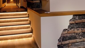 Un escalier avec des marches en bois et un mur en pierre.