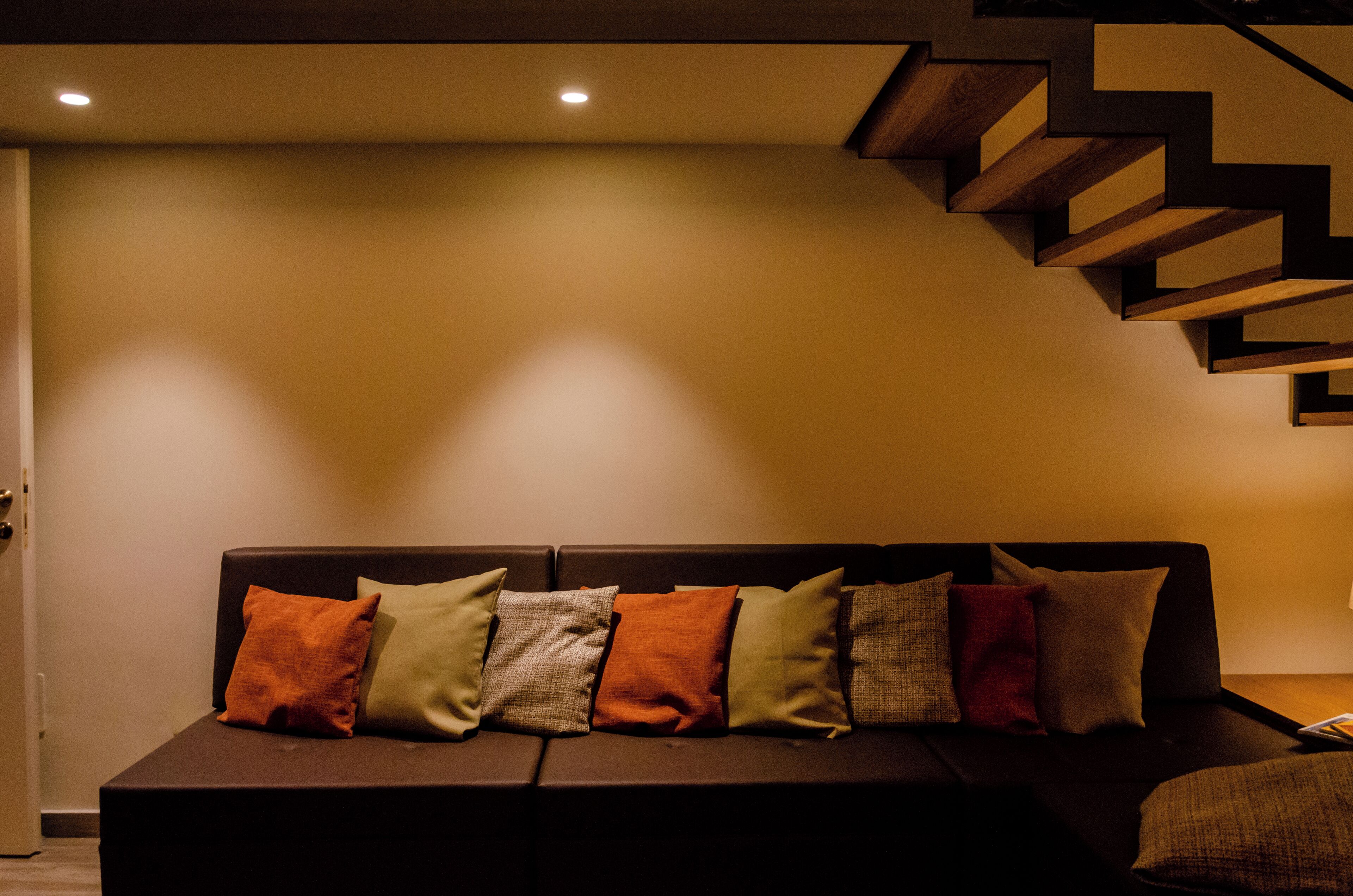 Ein modernes Wohnzimmer mit einer Couch und einer Holztreppe.