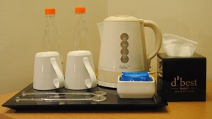 A coffee maker, two cups, a tissue box, and a box labeled "d'best hotel BANDUNG" on a tray. - La Asiana Express Hotel (Bandung)