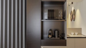 A modern kitchen with a built-in microwave, coffee maker, and a shelf with a kettle. - ApartmentsArena - Palazzo Cignaroli® - Il Maestro (Verona)