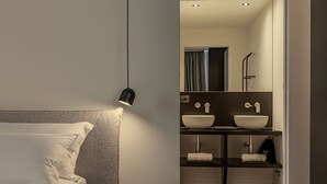 A modern bedroom with a bed, bedside lamp, and a nightstand with a book. - ApartmentsArena - Palazzo Cignaroli® - Il Maestro (Verona)