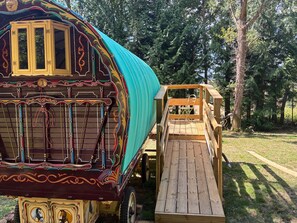 A colorful, ornate carriage with a wooden ramp leading up to a platform. - 2 Guests - Pet Friendly - Traditional Gypsy Vardo (Longhope)