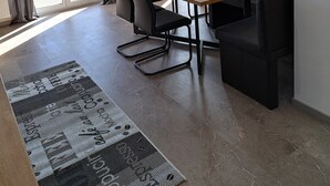 A modern dining area with a wooden table, black chairs, and a patterned rug. - "Vacations on the sunny side of the Semmering in Breitenstein" (Niederösterreich)