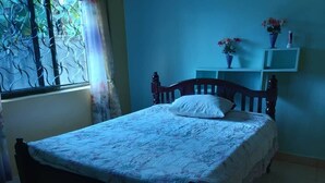 A bedroom with a bed, a window with a view, and a shelf with items. - Ikirunga View Homestay Kisoro (Nyarusiza)