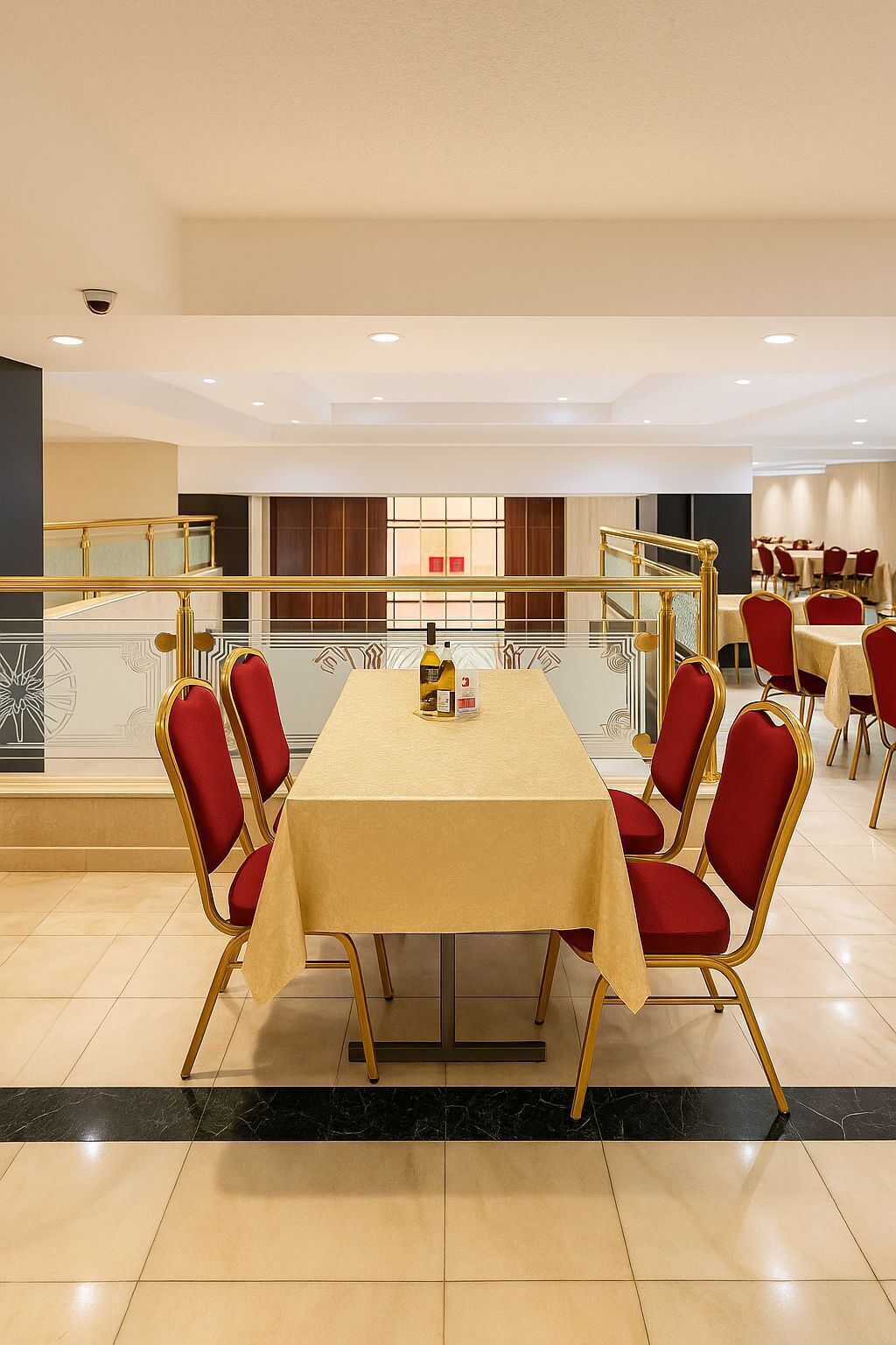 Een vergaderruimte met een lange tafel, rode stoelen en een gouden balustrade.