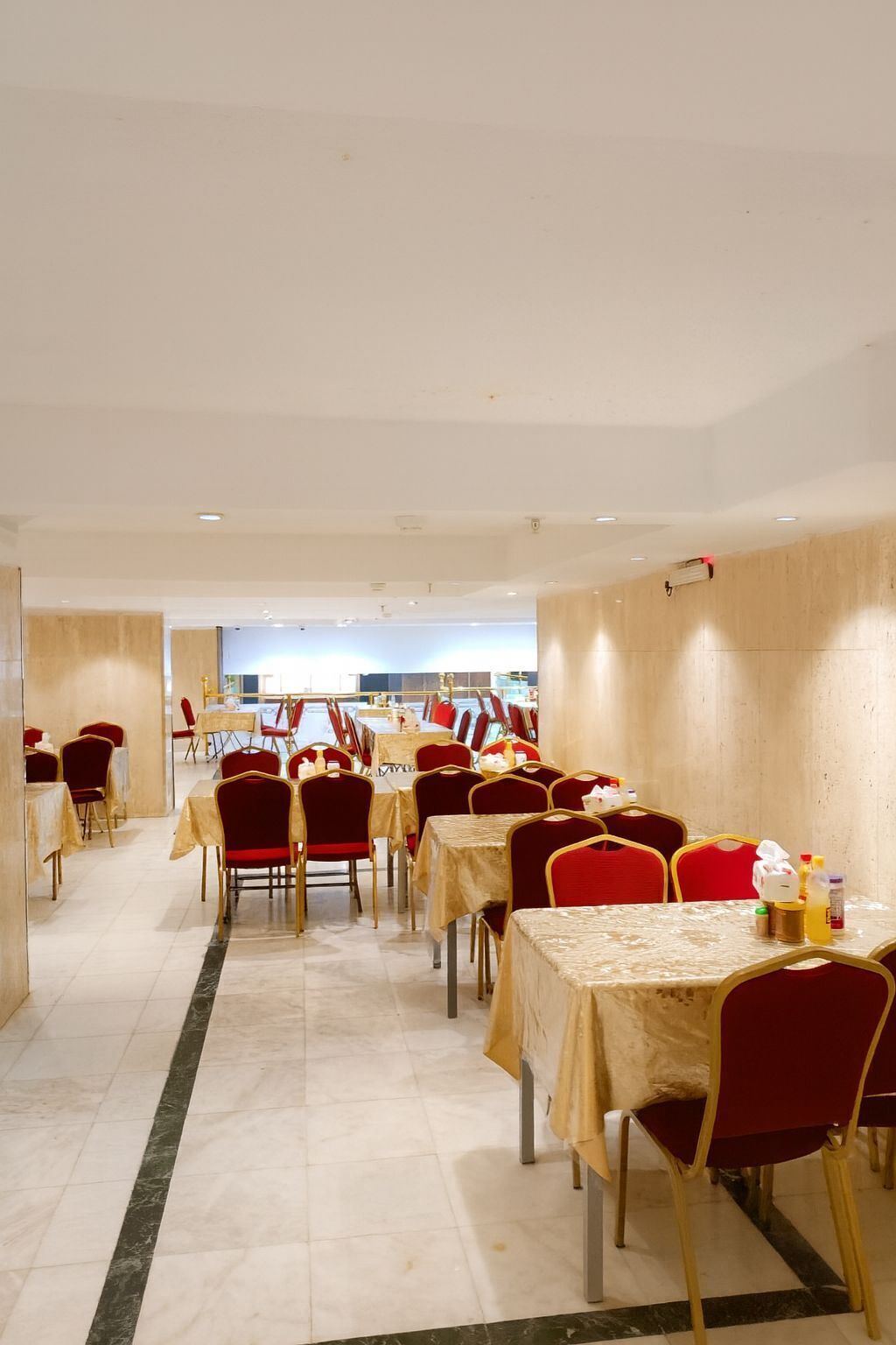 A dining area with multiple tables and chairs, arranged in rows.