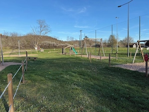 A playground with swings, a slide, and a climbing structure.