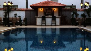 A pool area with a bar and seating, surrounded by walls and decorative lighting. - SO DALYAN (Dalyan)