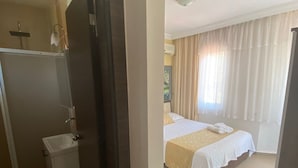 A hotel room with a bed, a small bathroom, and a view of the outside. - SO DALYAN (Dalyan)