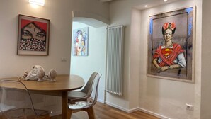 Een eethoek met een ronde tafel, stoelen en wanddecoratie.