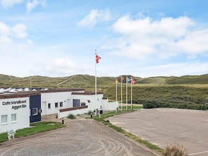 A building labeled 'Cafe Vandkant' with a gravel driveway leading to a parking area.