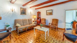 A living room with a herringbone floor, wooden beams, a sofa, chairs, a table, and wall-mounted lamps. - 'Chez Martha' with Mountain View, Private Terrace and Garden (Anduze)