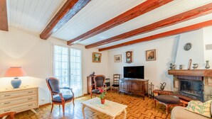 A living room with a fireplace, wooden furniture, a television, and a patterned floor. - 'Chez Martha' with Mountain View, Private Terrace and Garden (Anduze)